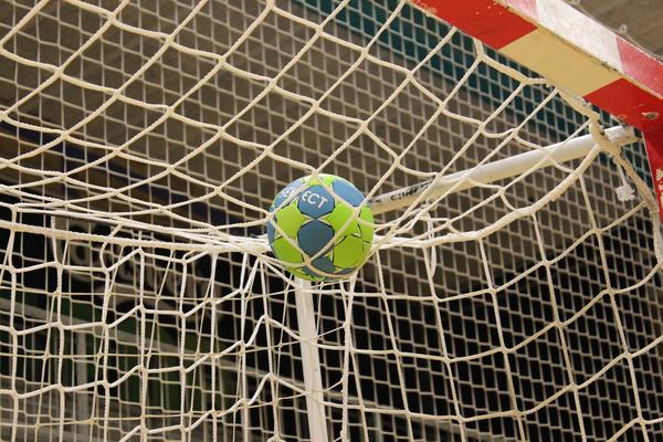 Bild vergrößern: Oberer Teil eines Handballtores mit Handball auf dem Netz